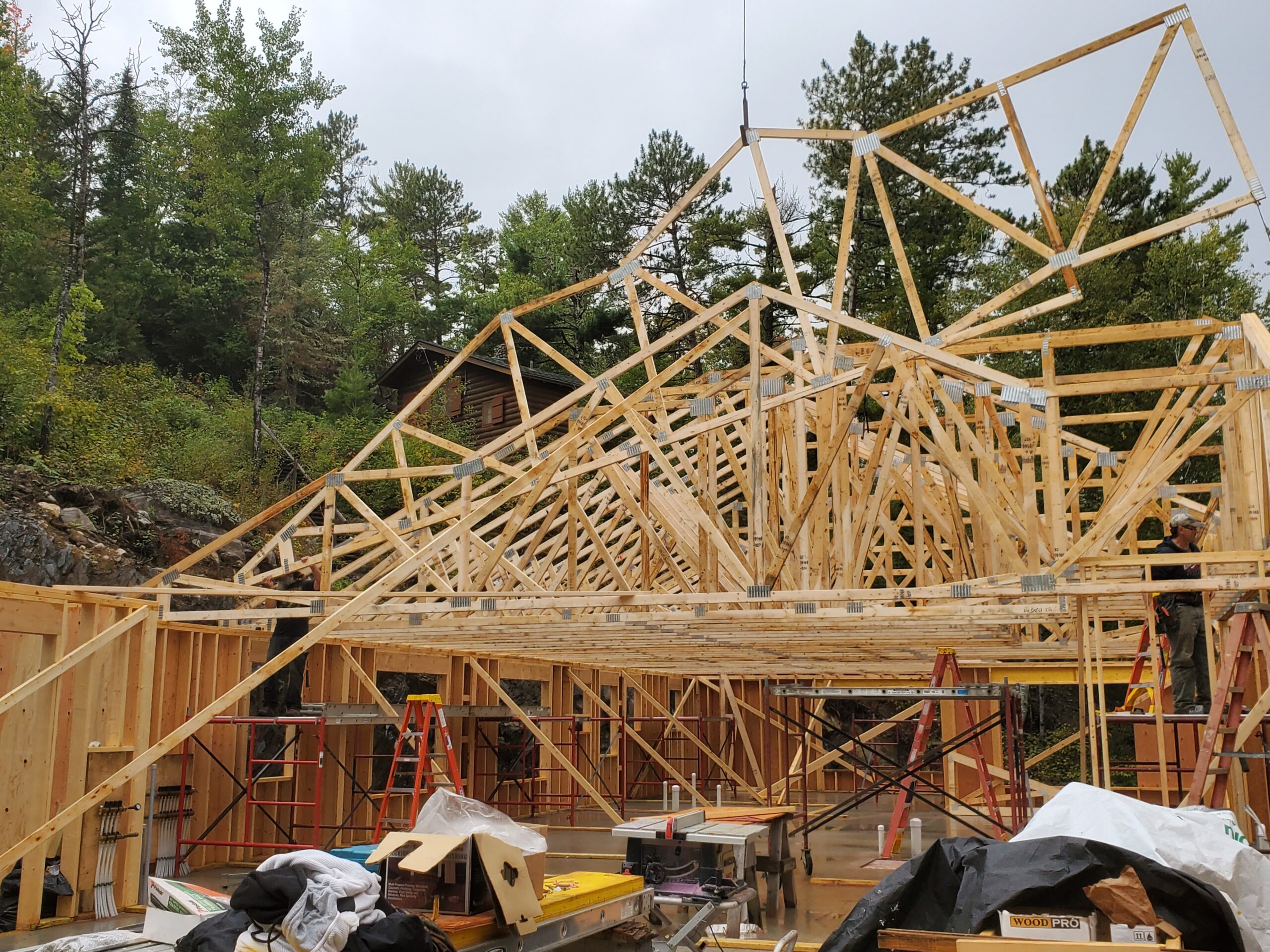 Crane setting trusses, custom home by Huisman Concepts